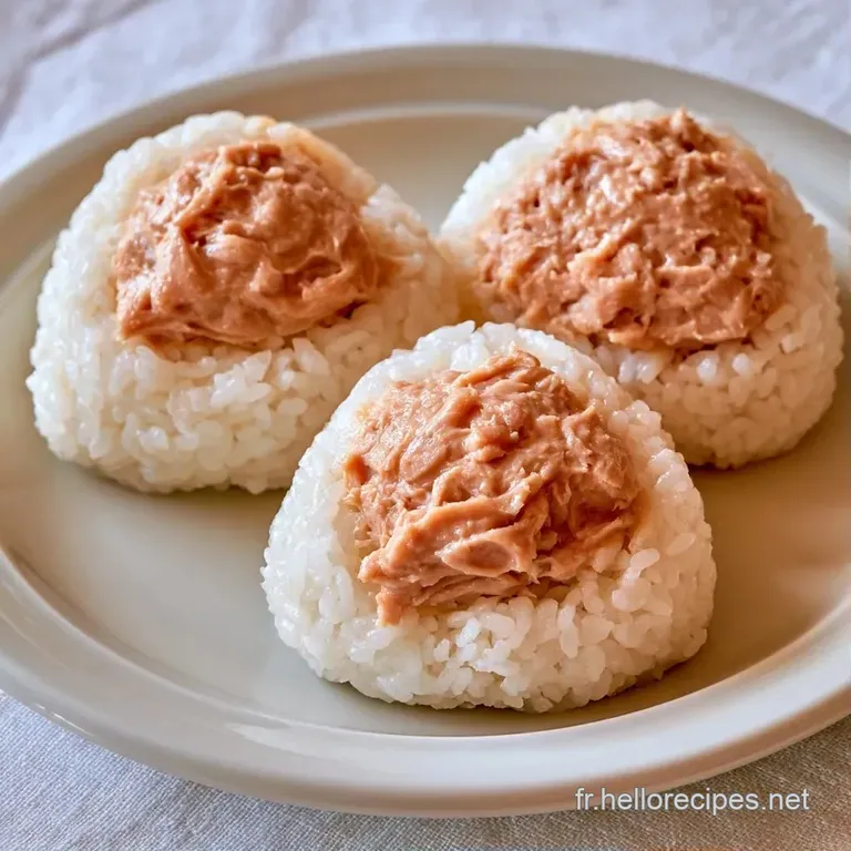 Riz blanc moul&eacute; en triangles, pos&eacute; sur une assiette en c&eacute;ramique grise avec quelques graines de s&eacute;same torr&eacute;fi&eacute;es.